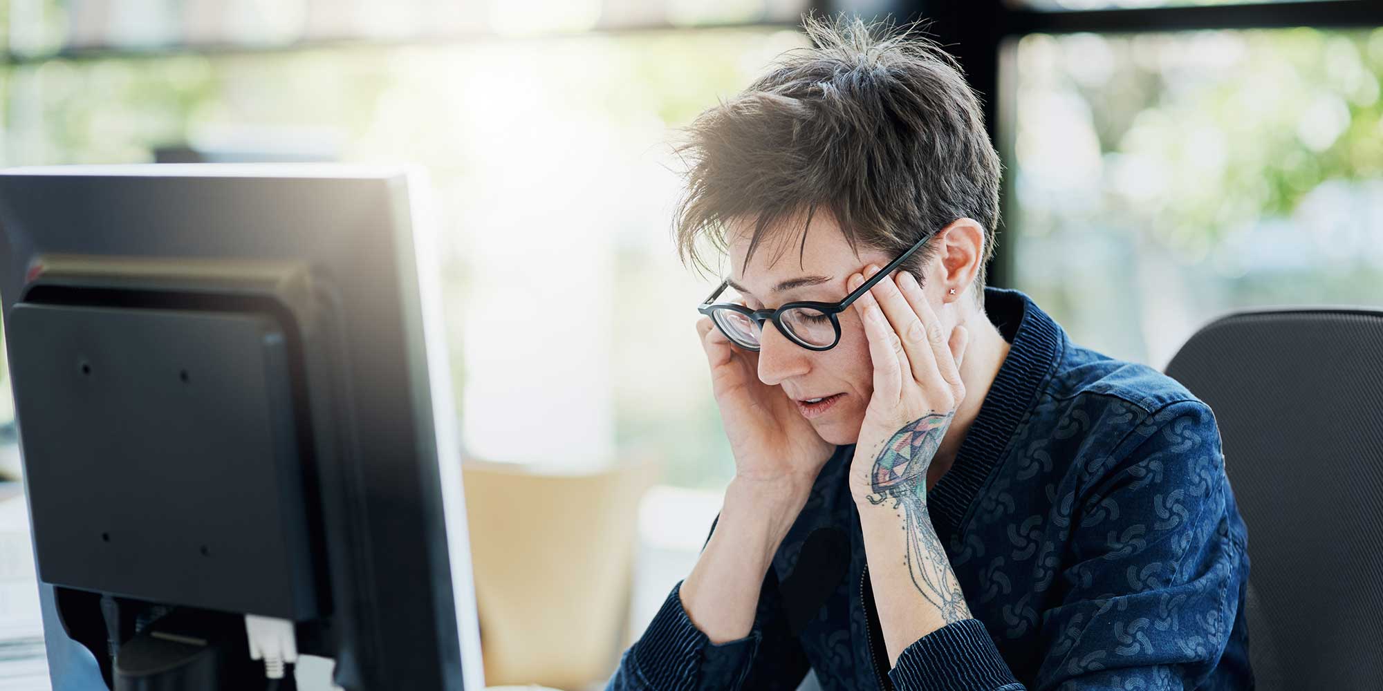 A brown and cream snail crawls on a black laptop keyboard, with its shell prominently displayed.