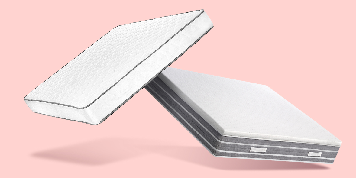 Dual-layer mattress with a white top layer and a grey base, set against a soft pink background.