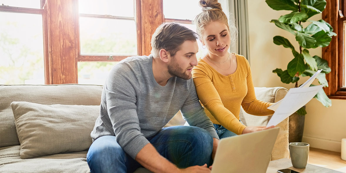 Couple comparing energy deals with a laptop and bill