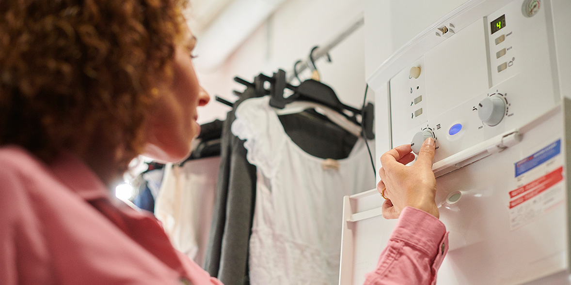 Somebody turning a dial on their boiler control panel 