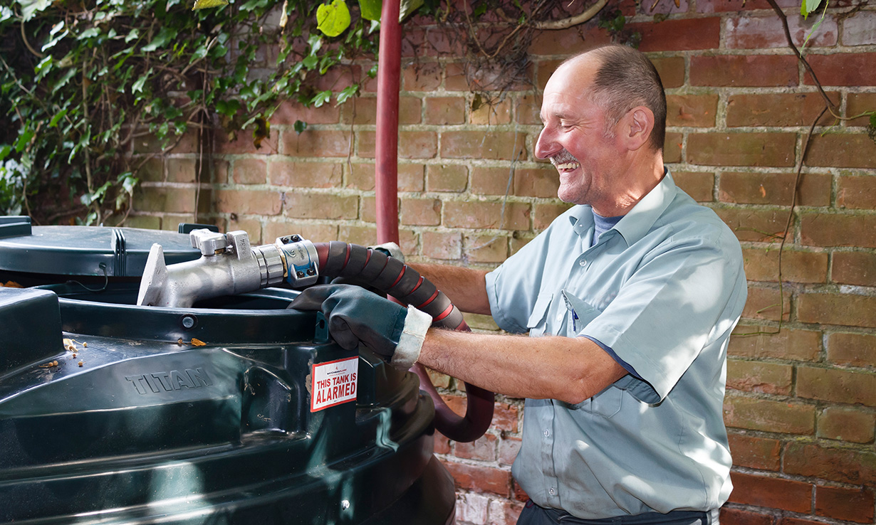 man filling a heating oil tank with kerosene